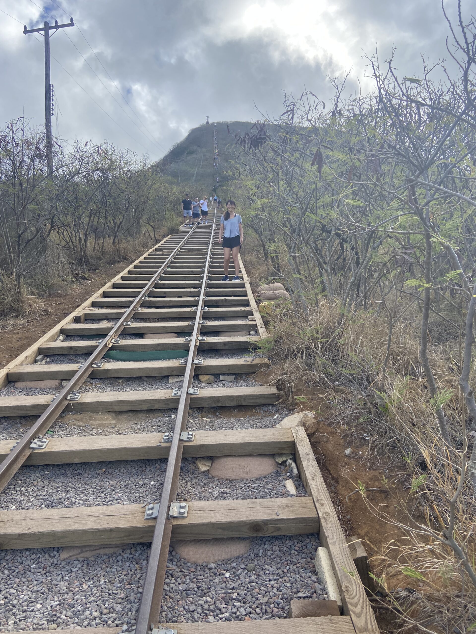 Rail tracks leading to Koko Head crater in Hawaii with a view of the crater summit.